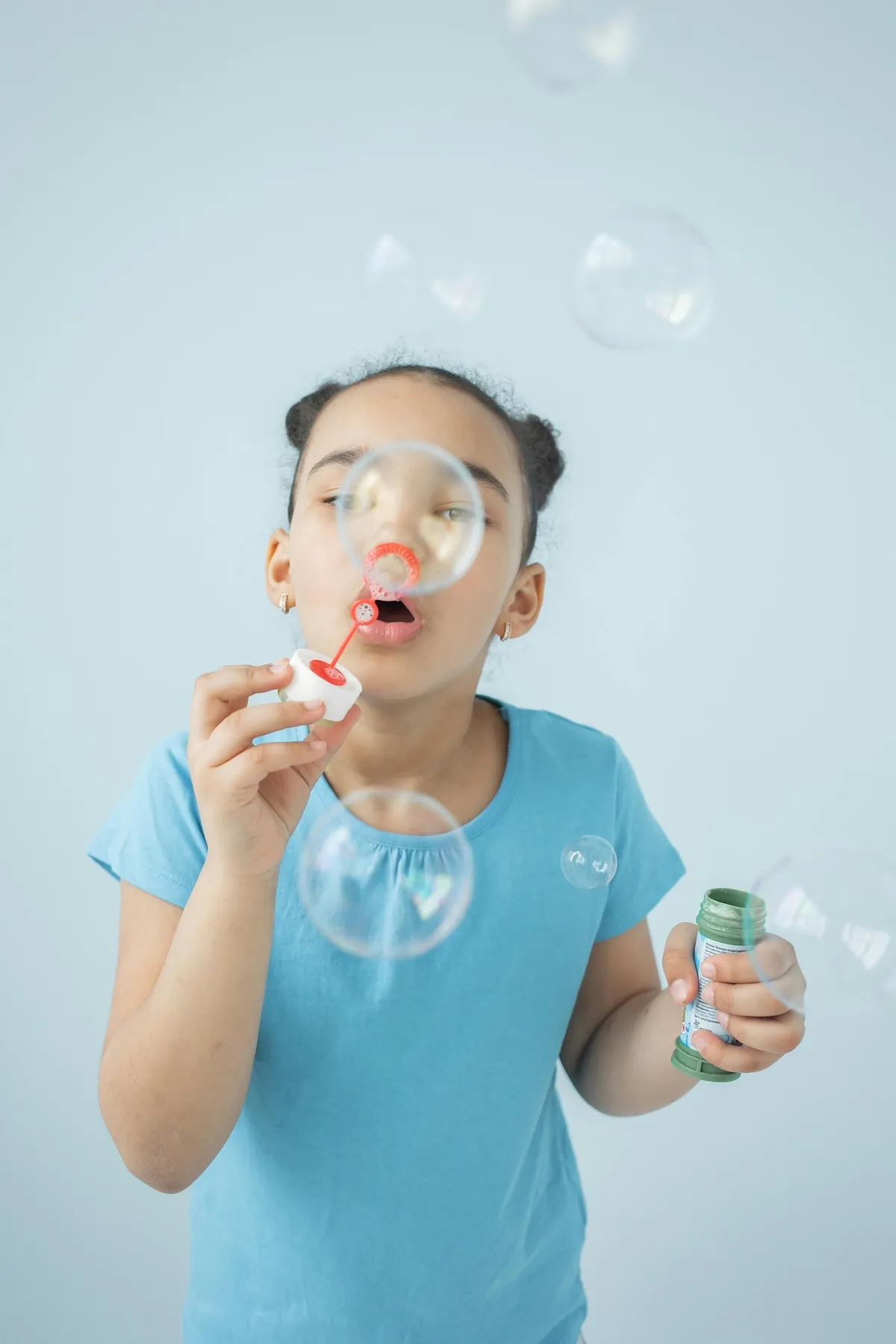 Happy child blowing bubbles during play therapy at Revive Health Therqapy