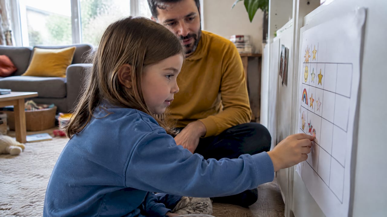 Child adds sticker during parent coaching